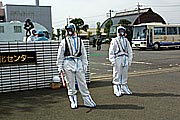 防護服をつけ交通整理に当たる警官