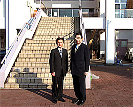 県立あすなろの郷の管理棟前で井手よしひろ県議（右）と高崎進県議